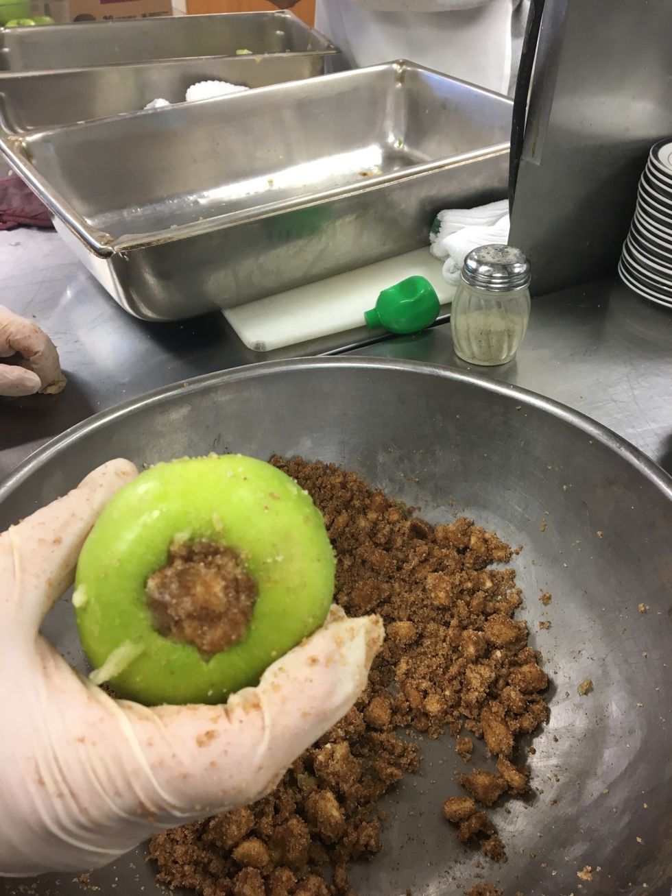 Pack the mixture of butter, brown sugar, and cinnamon in the center of the apple