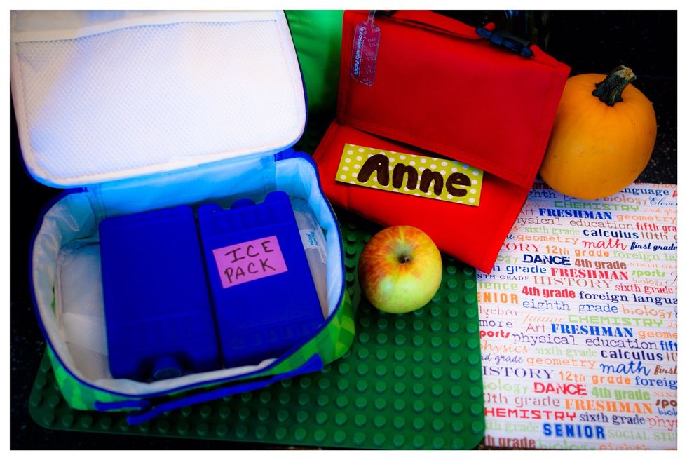 Pack your perishable items in your lunch bag. To begin, first open up your lunch bag and place frozen freezer pack on the bottom.