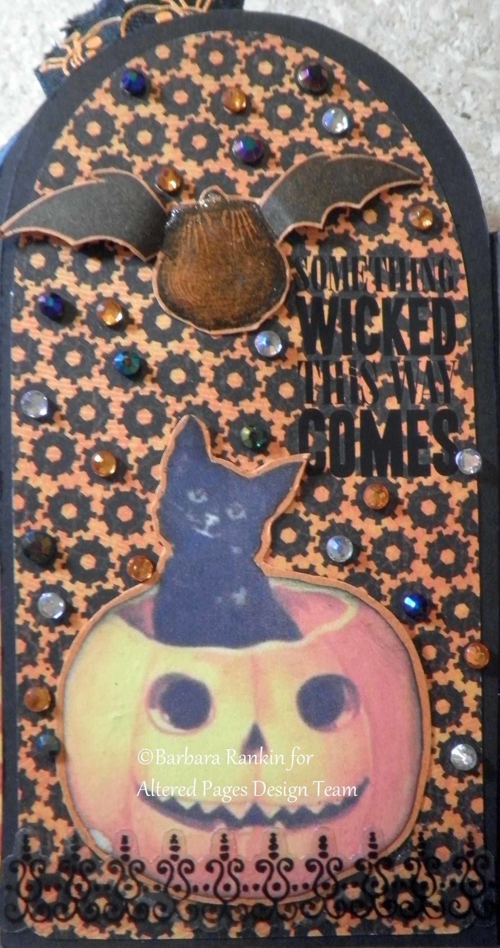 Page 7 right: Fussy cut AP-288 Happy Halloween collage image, wrought iron sticker, rub on quote, Sin City Stamps flying pot stamped in black onto orange CS, fussy cut, Crystal Lacquer on pot.