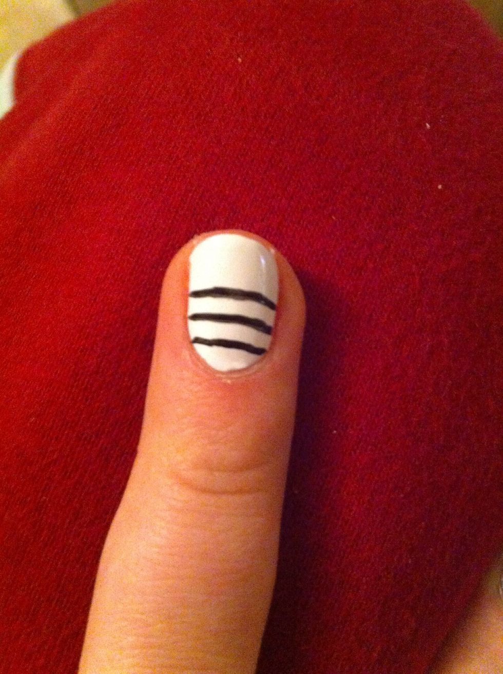 Paint 3 black lines on the lower part of your nail (I used a pen liquid eyeliner because they are a MUCH more controllable way to do it- however you will need a top coat)