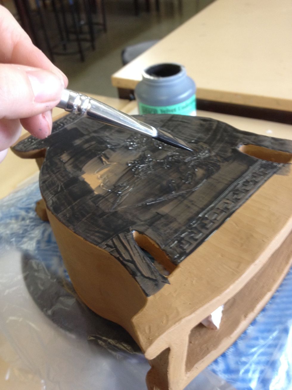Paint desired areas with two coats of underglaze. Best results will cover the designs.