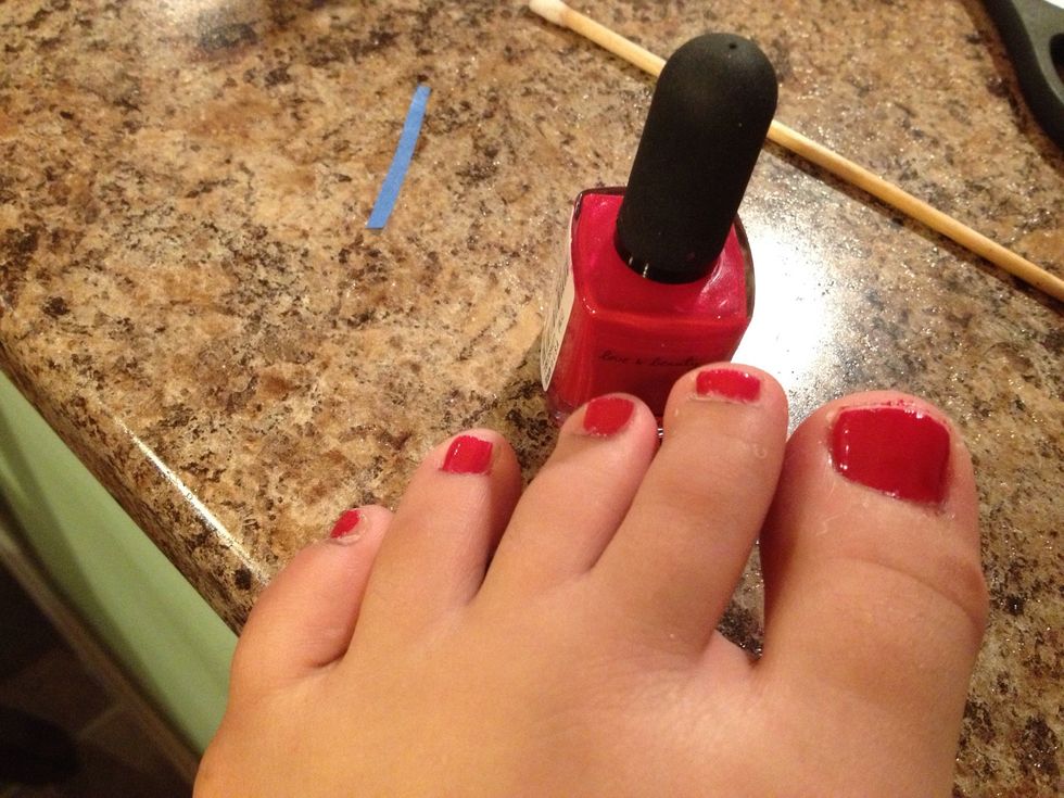 Paint one layer of red on your toe nails.