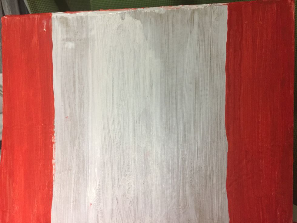 Paint red stripes onto the sides of one large piece of cardboard.