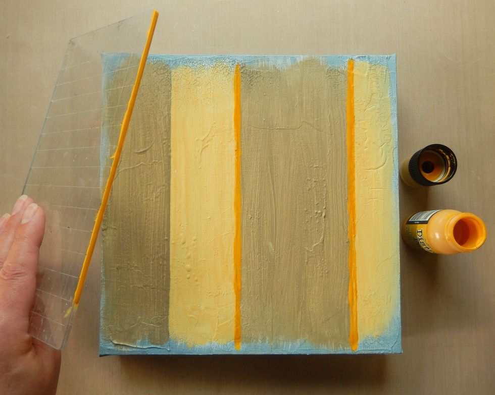 Paint stripes of Frayed Burlap and Scattered Straw Distress Paint between the lines. Then apply thick lines of Fossilized Amber Distress Paint using the edge of your stamp block.