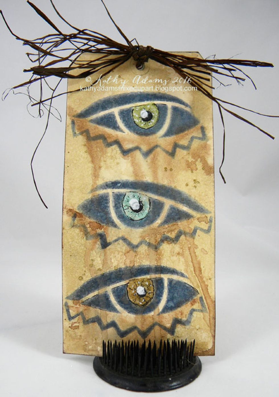 Paint the background Warm Colorations Spray mixed with water and let dry. Add French Toast Spray under each eye and add water, letting the color drip. I colored each eye a different color