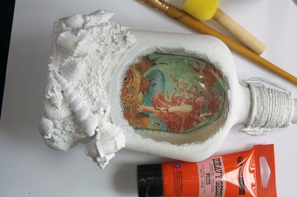 Paint the bottle & all embellishments with 2 coats of Heavy White Gesso, leaving a window on the front to see the image inside. Use a sponge dabber for the gesso on the glass for added texture.