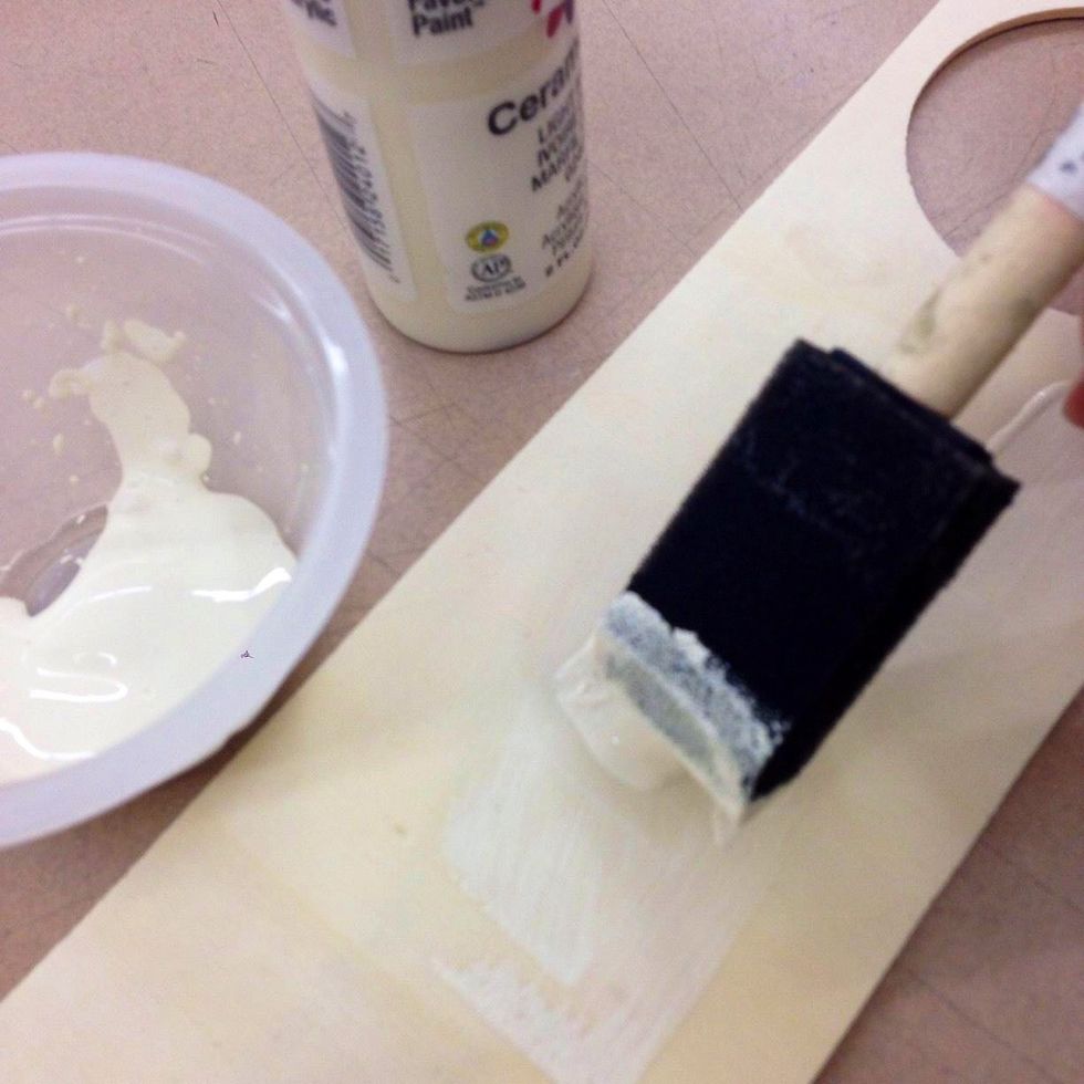 Paint the center area of your door hanger with ivory paint.