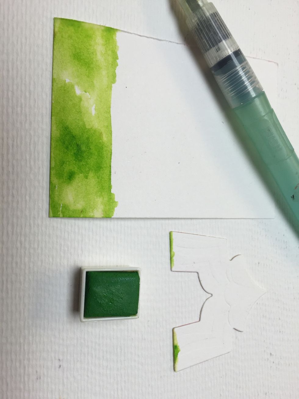 Paint the lower quarter of your paper in green. Paint a bit on the lower side of your tent so you already have grass when you glue it down