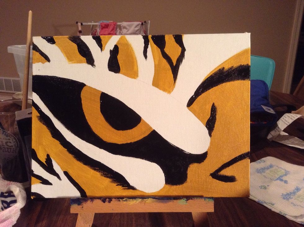 Paint your black spaces over the gold: the pupil, eye area, and stripes. The stripes should have rough, feathered edges to look like fur. The pupil should be as smooth edged as possible.