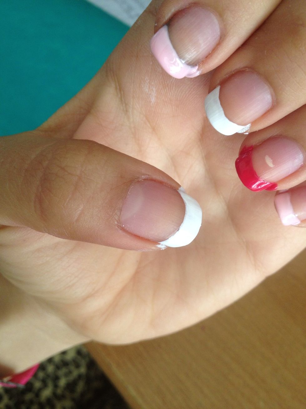 Paint your nails as a french manicure. 2 nails with the white nail polish, 2 nails with the light pink nail polish and 1 nail with the dark pink nail polish.