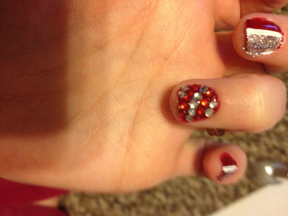 Paint your ring finger nail with a clear polish, (or the glitter polish) and place on your rhinestones alternating the colors of red and silver