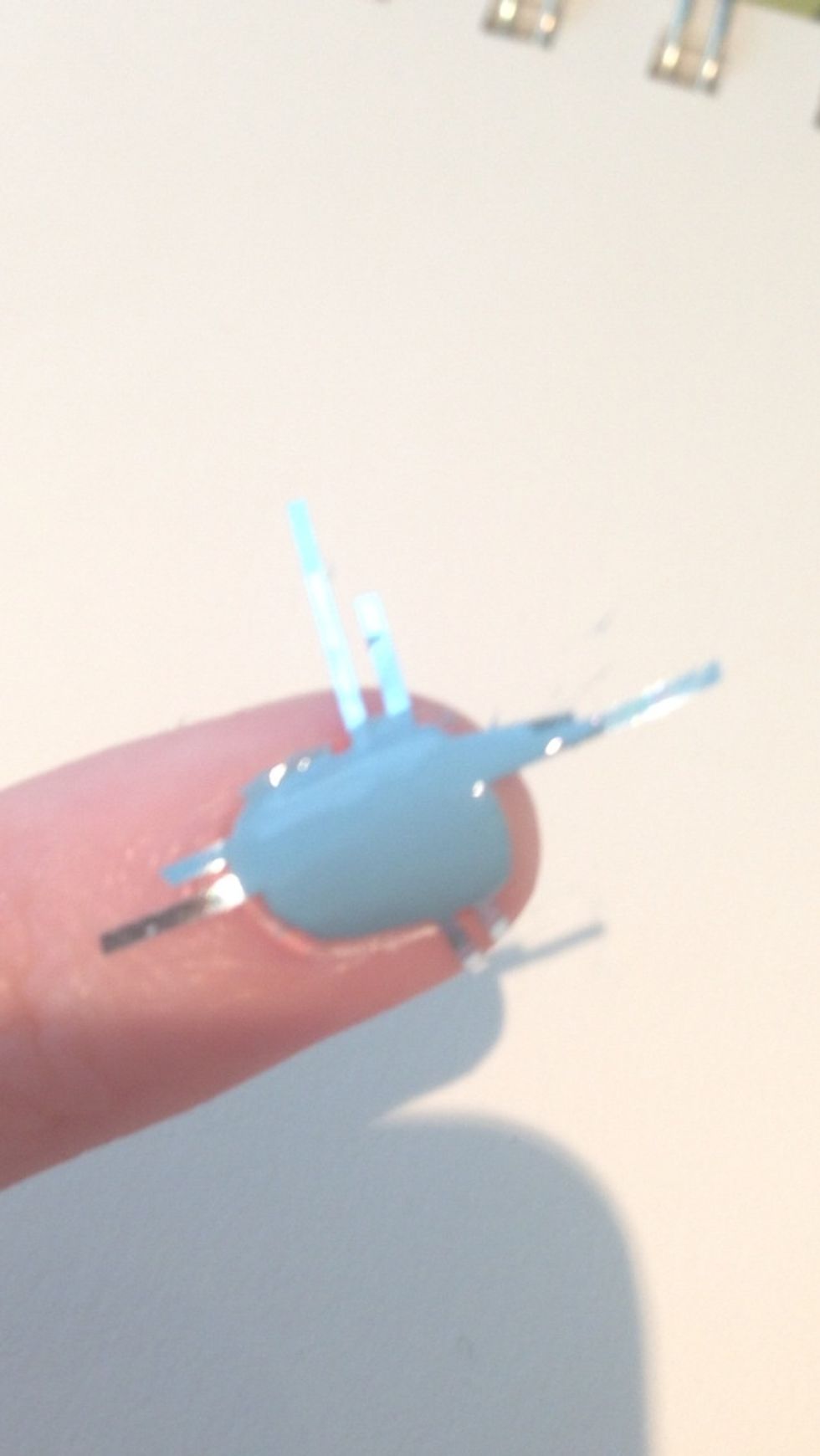 Paint your second color on top of the first covering all of the tape that's on your nails. Don't worry if the polish gets on your skin, we can clean it up later.