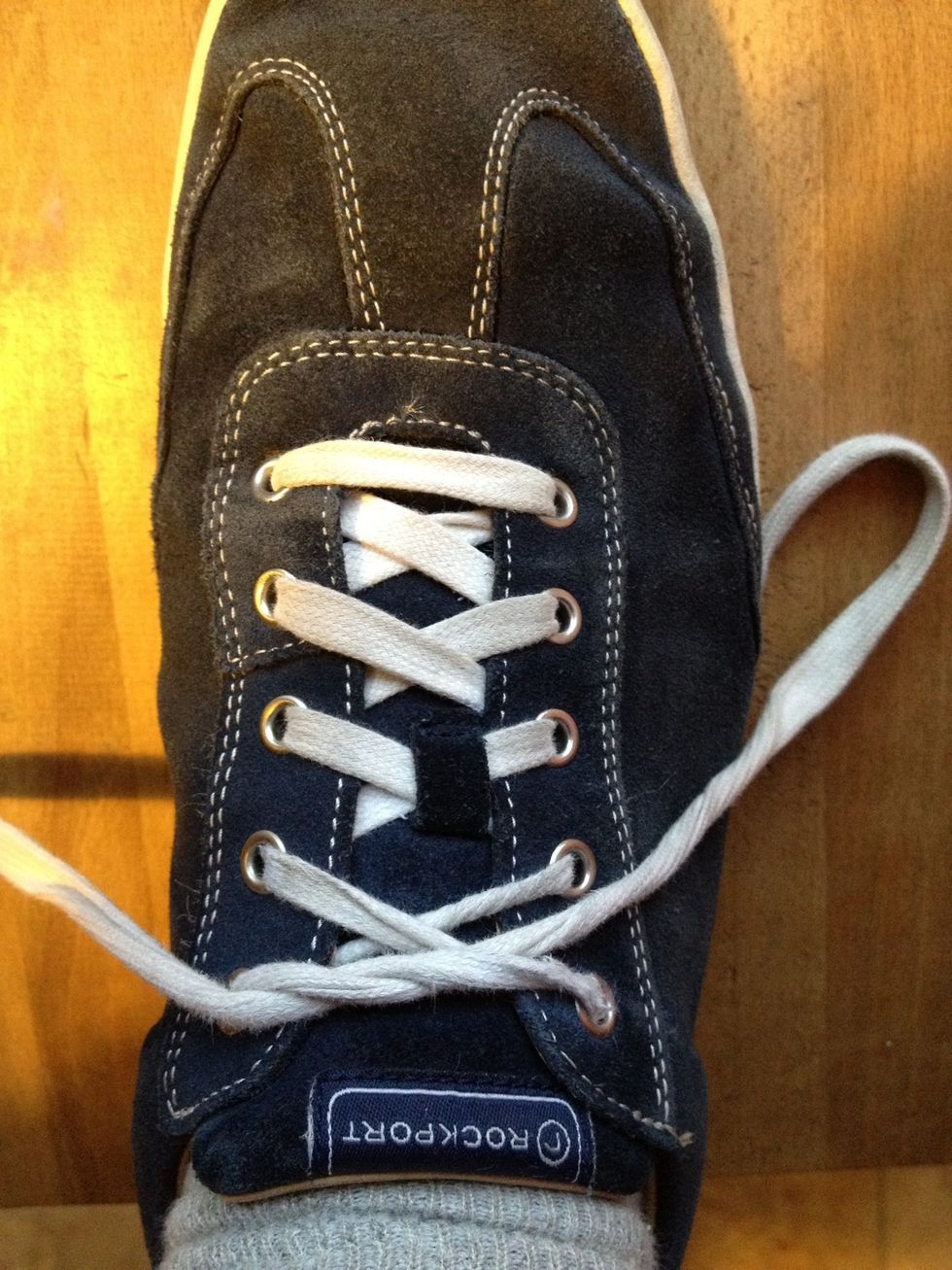 Pass the right lace under and through. Pull it tight.