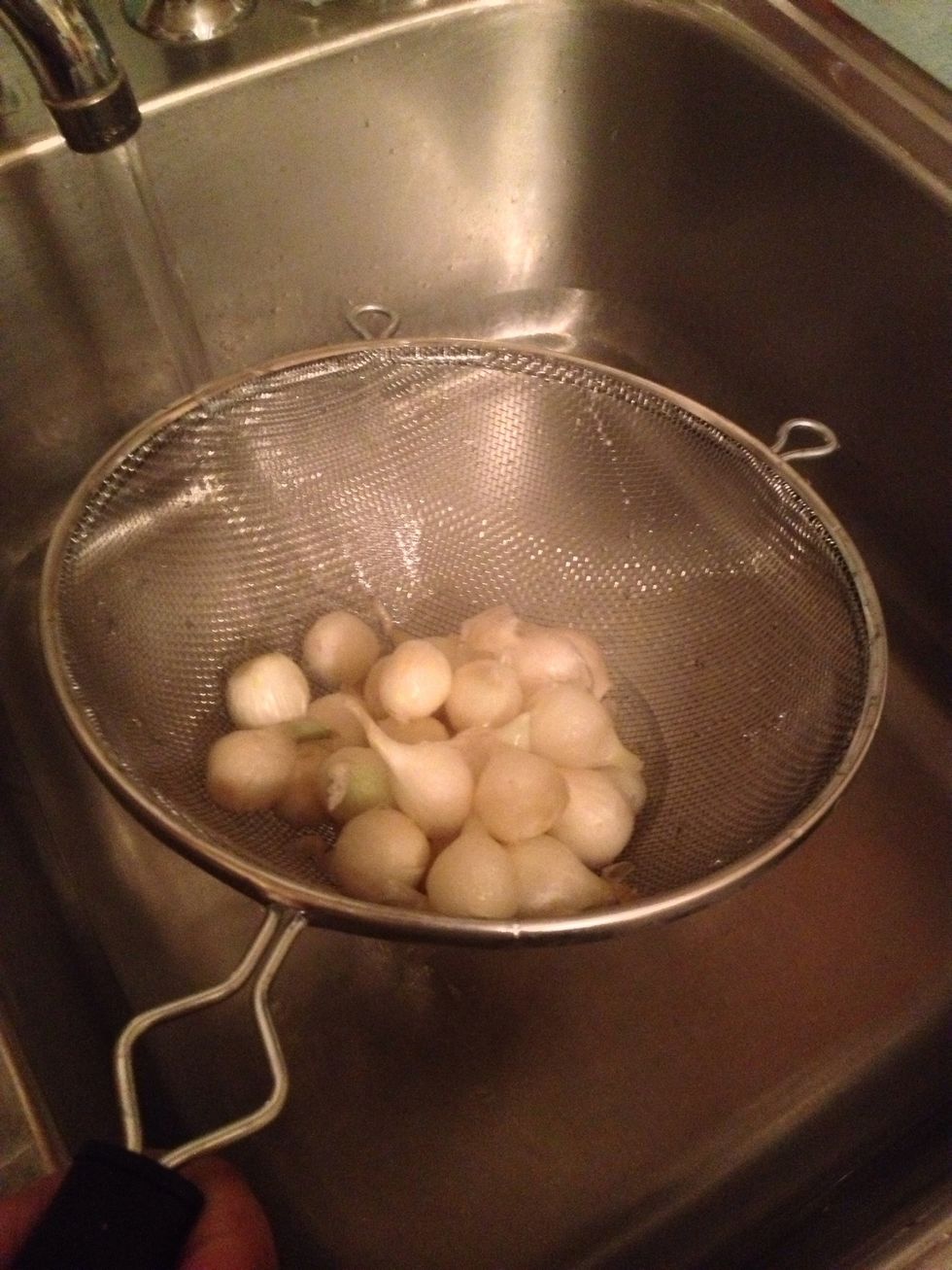 Pass them through a strainer, over the sink.  Use caution, the water is hot and you don't want  the water to splash on you.