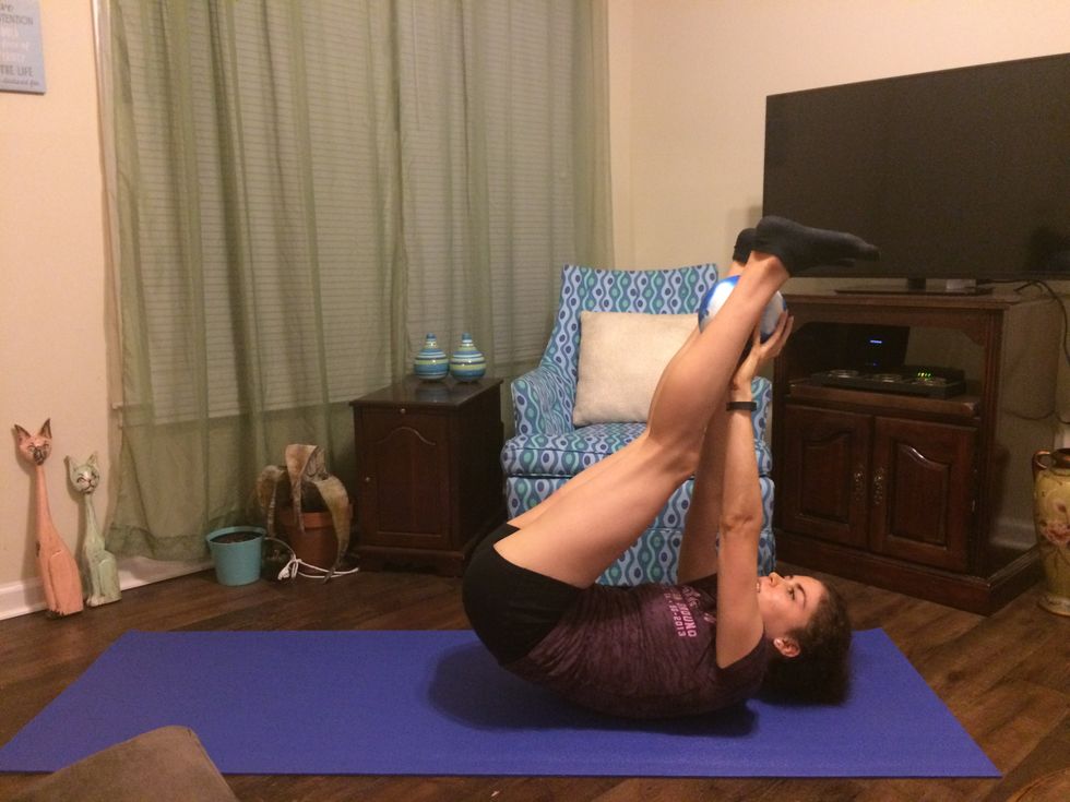 Passing Ball: Lift your legs and your arms up. Place the ball between your ankles.