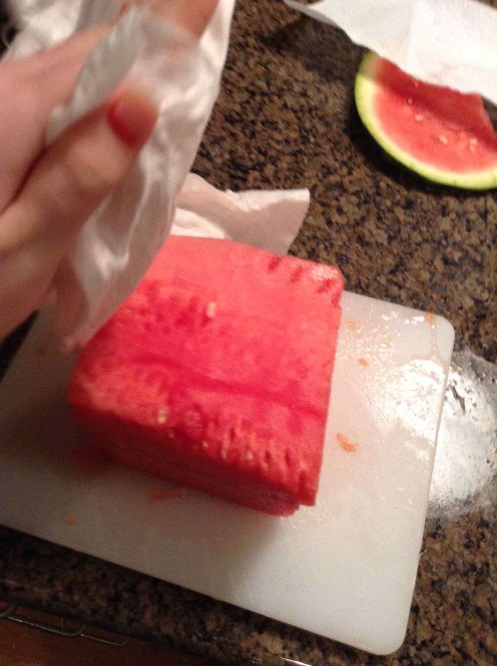 Pat the watermelon cube off with a paper towel to soak up the juices.