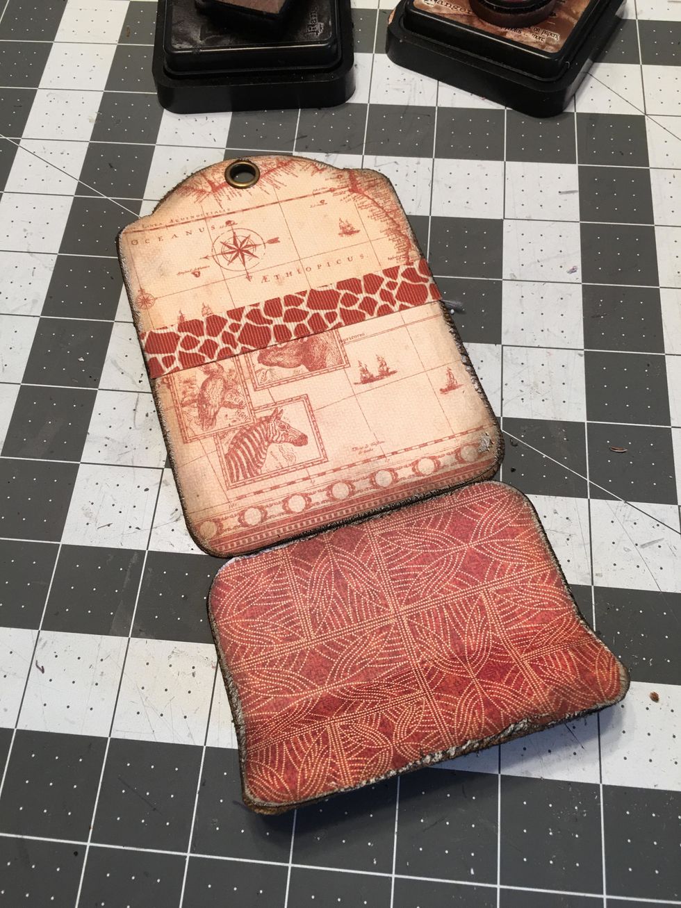 Pattern the front side of the tag as shown, add a ribbon for a belly band (only put glue on each end of the ribbon), pattern the bottom part to cover up the magnets. Ink all edges as shown.