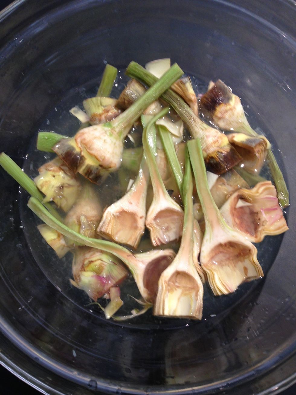 Peel and core the artichokes. Cut in half and as you go put them in water- lemon. To prevent oxidation and becoming black
