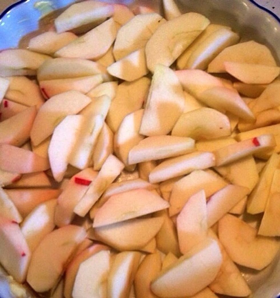 Peel and slice the apples. Butter a pie tin and place the apples in it.