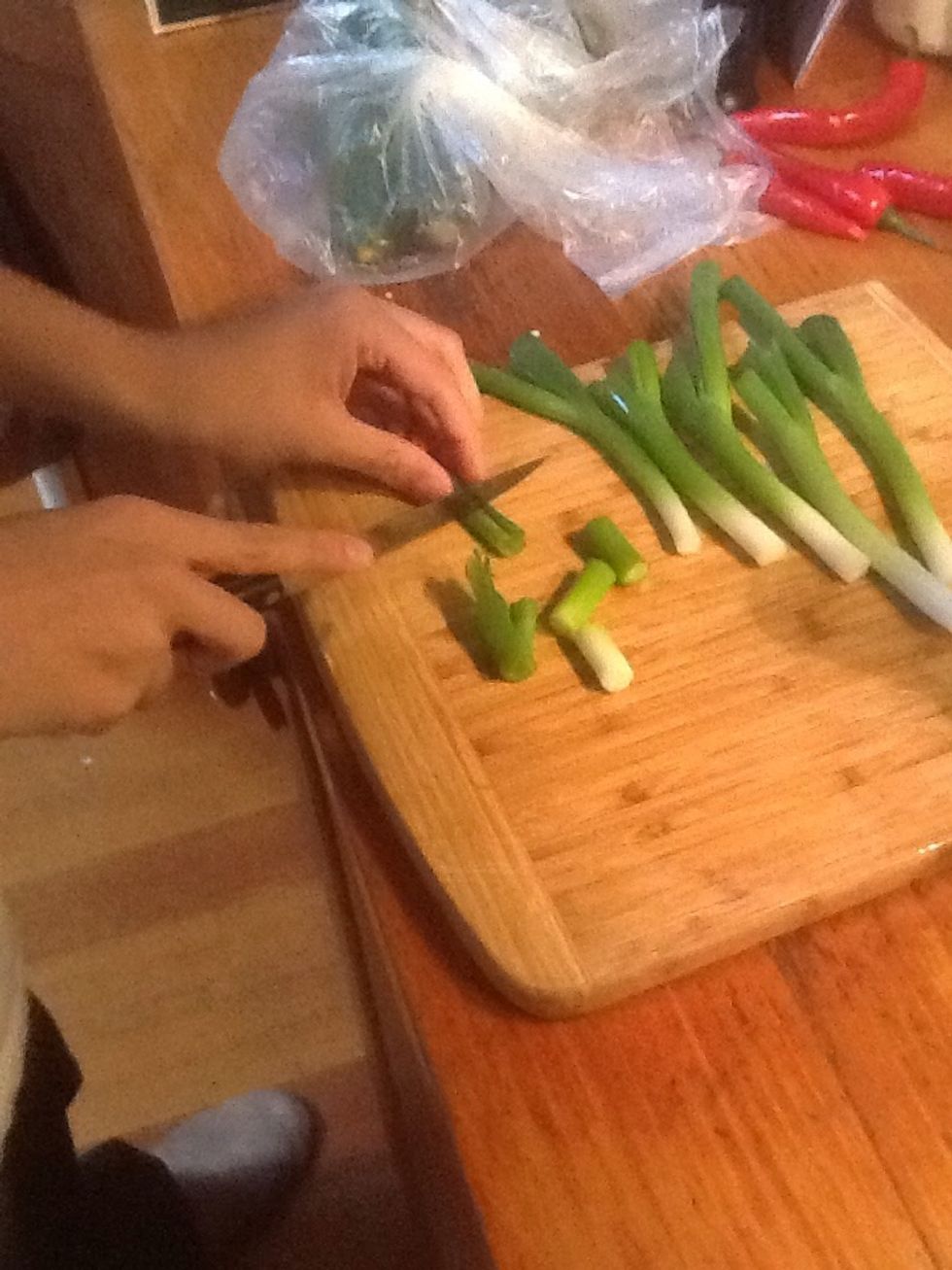 Peel and wash the spring onion, cut it into 2cm pieces.