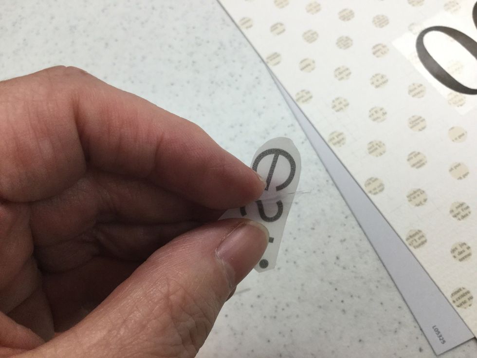 Peel away clear adhesive film from corner of design to reveal a sticky surface beneath. As you work on peeling up the film, check to be sure that you are not mistakenly peeling up the image as well.