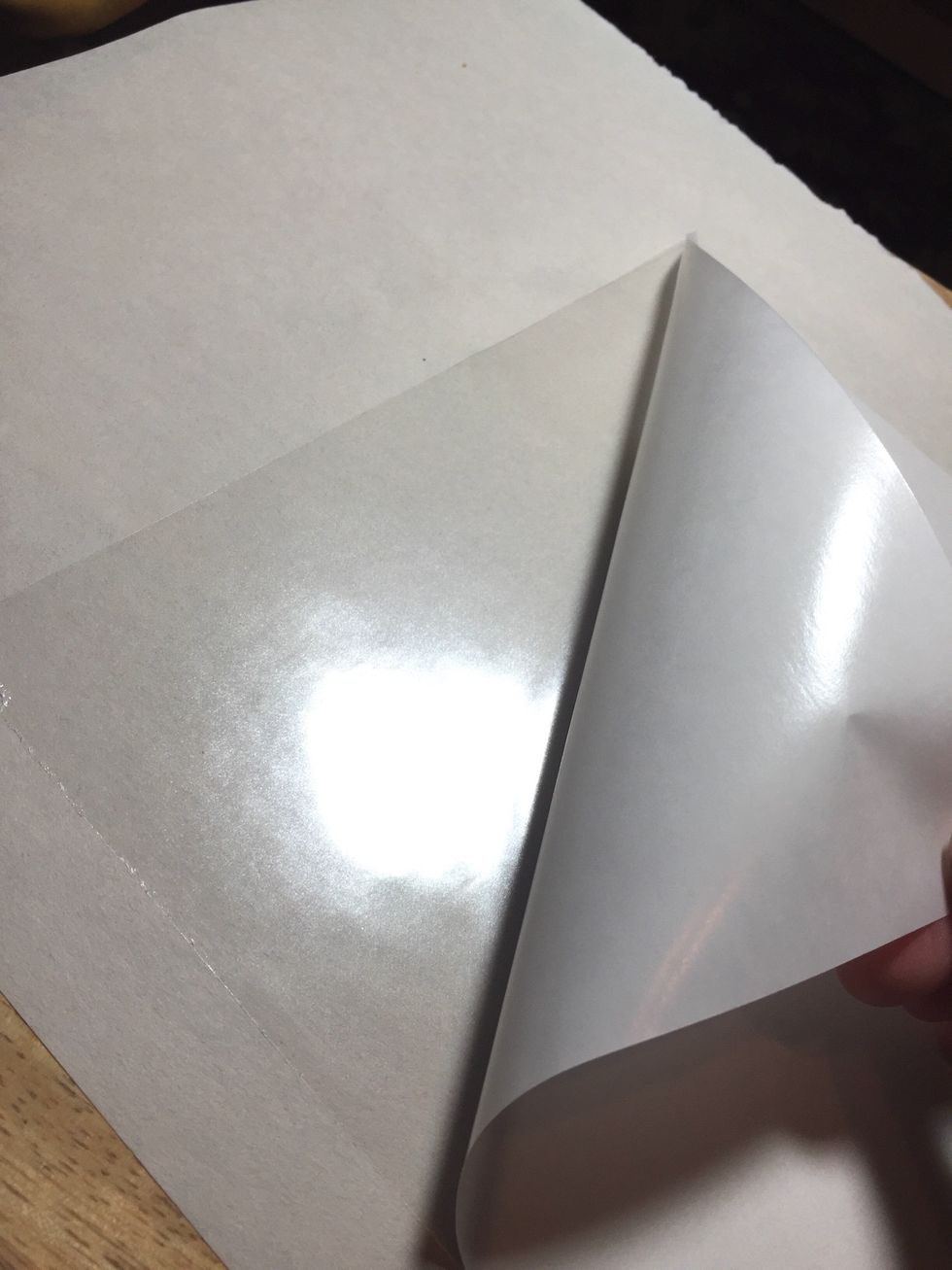 peel back a corner of the liner from the adhesive sheet.