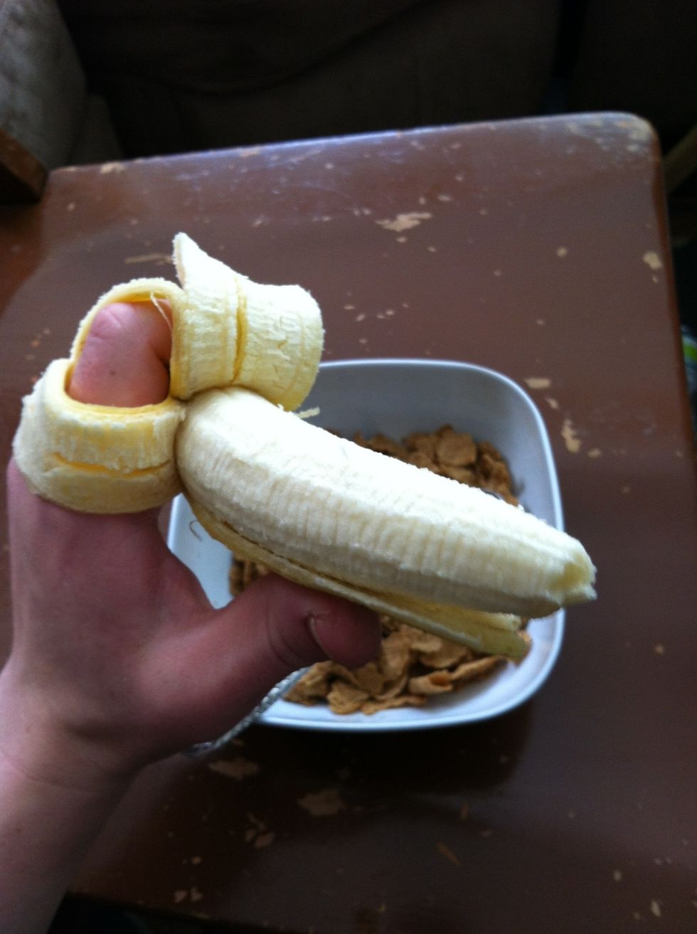 Peel banana like so...while keeping one side in place so to hold it up