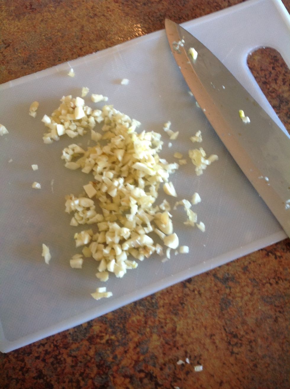 Peel garlic then using flat side of knife press down to crush the garlic. Then diced into small pieces.