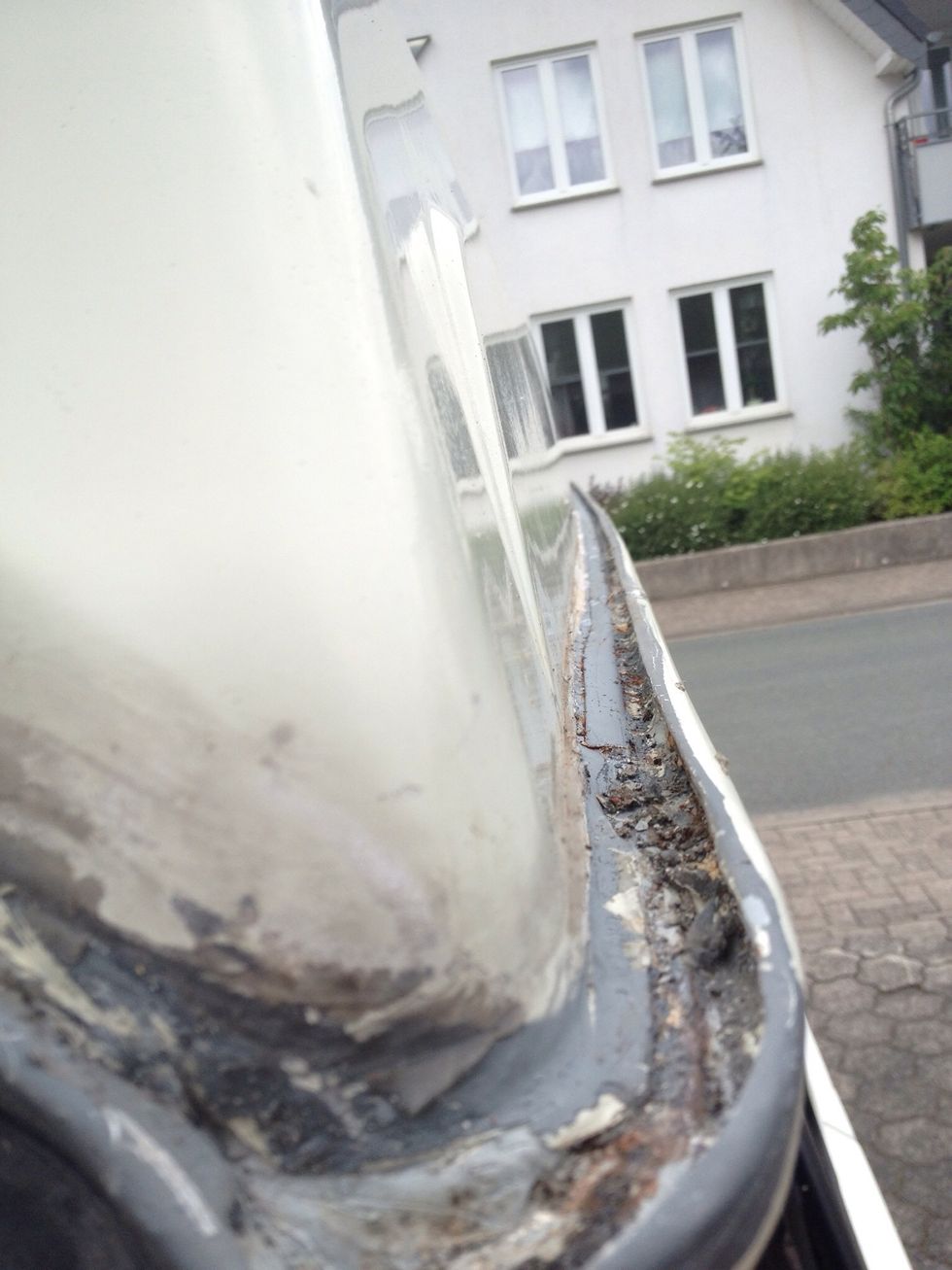 Peel off all silicone or whatever else somebody thought might be a good idea to apply to cover rust. The rust comes from the inside. There is no shortcut to fix this but to take off the roof.