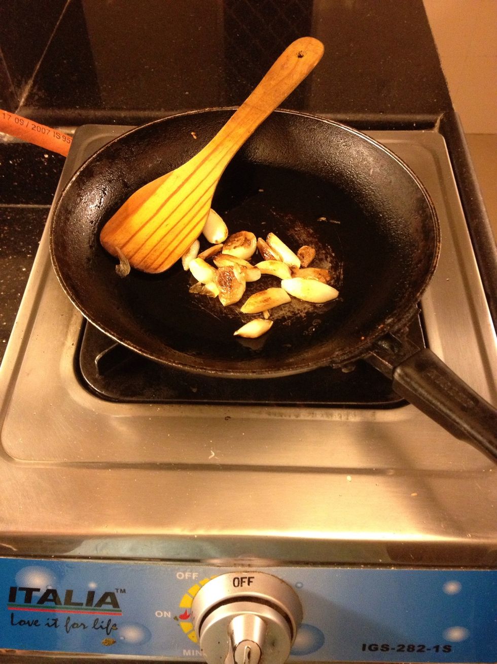 Peel off the skin from the garlic cloves and saut\u00e9 them in olive oil till they turn golden brown.
