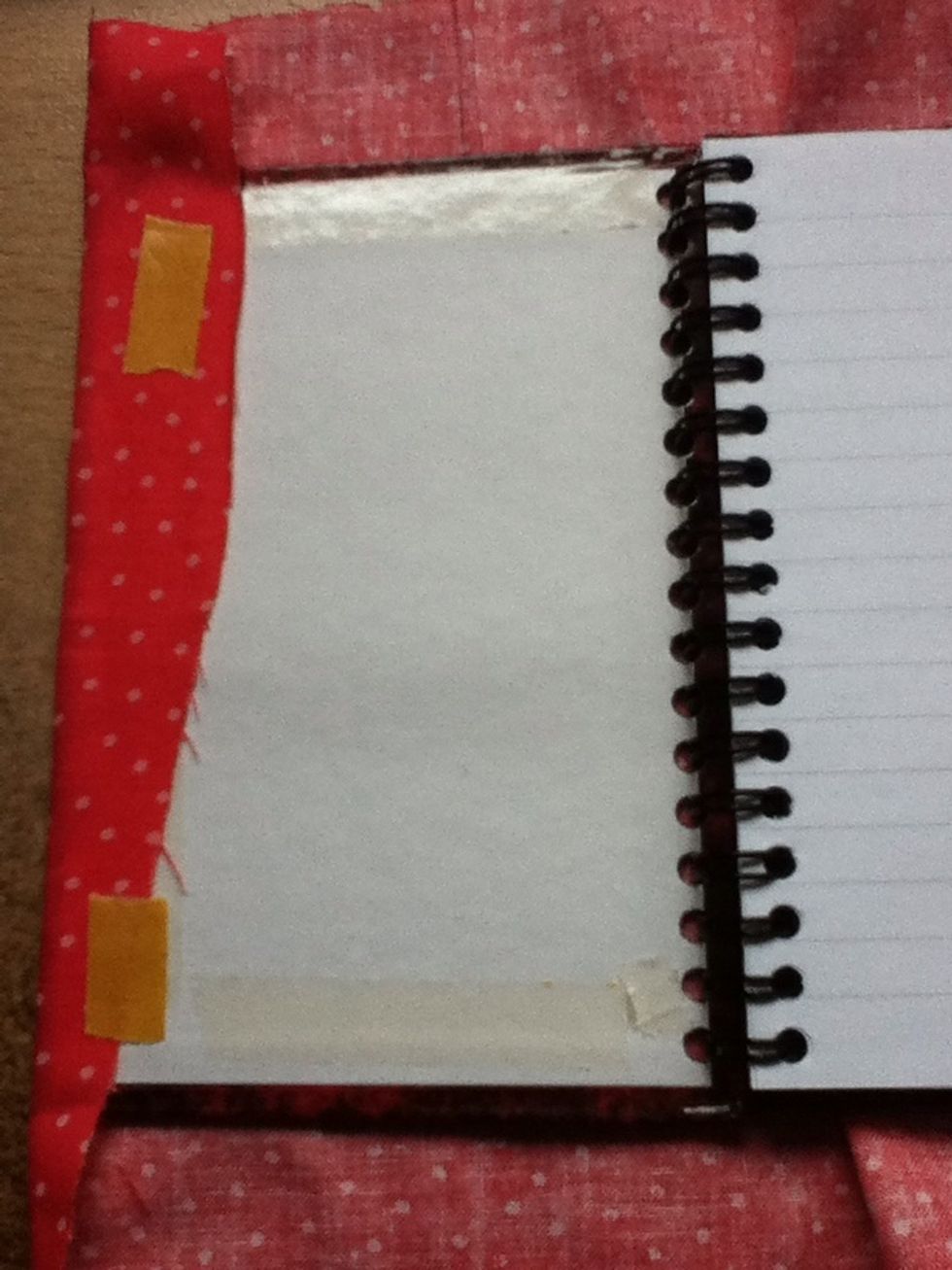 Peel off the tape on the inside of the notepad. Stick the longest side down first, and then put a small amount of tape on it as shown above.