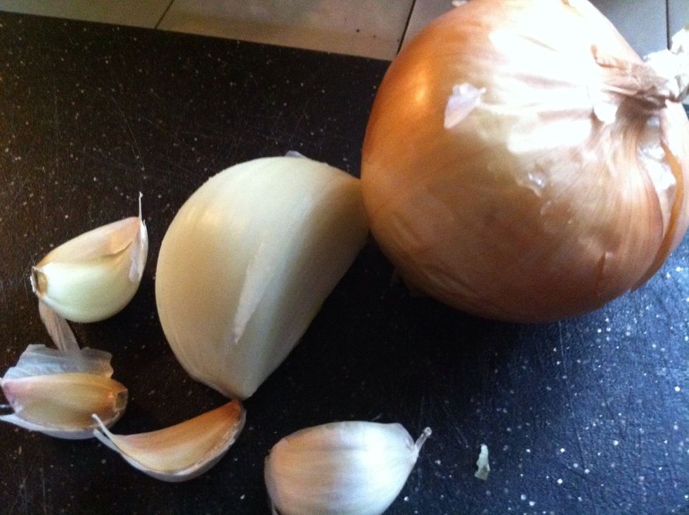 Peel one full onion and 3 to 4 cloves of garlic. You can use more or less depending on your taste. Add these to food chopper.
