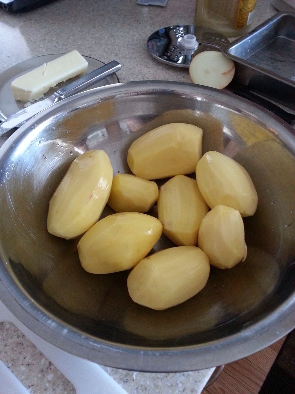 Peel potatoes. For a 9x13 pan, you'll need to peel about 5 lb bag.