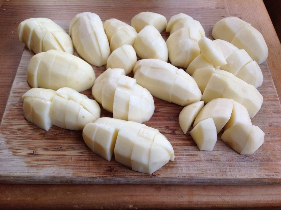 Peel potatoes then cut in half lengthwise.  Then cut each half down the middle, turn and cut the potatoes in 1 inch cubes.  Doesn't have to be exact but the more uniform the better they cook!
