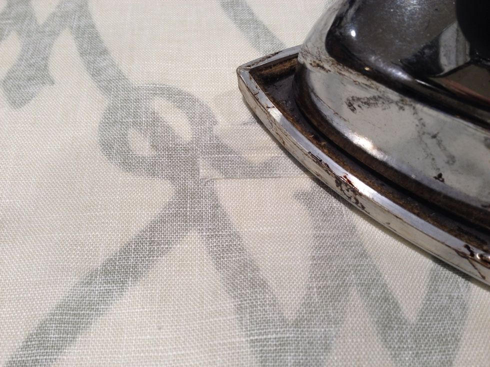 Peel the backing of the steam-a-seam. Place the small piece o fabric over the 1-1/2" mark at each side of the bottom of the shade. Press and steam.