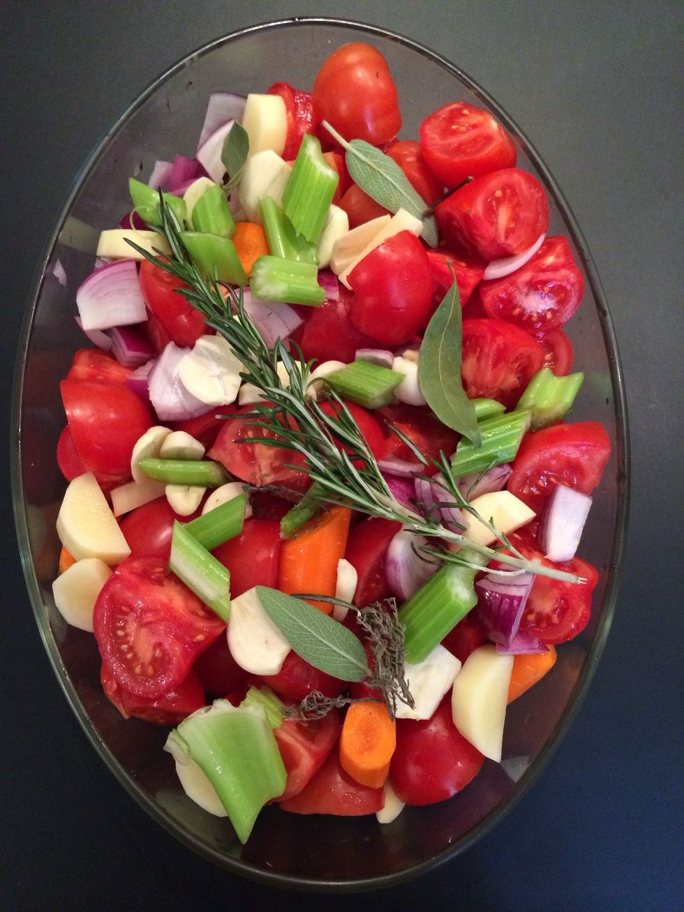 Peel the garlic, peel and dice the carrot and cut into 3, peel and dice the onion and the potato. Cut the tomatoes each into 4. Put all on the roasting pan. Add salt, pepper,bay leaves, thyme, rsomary