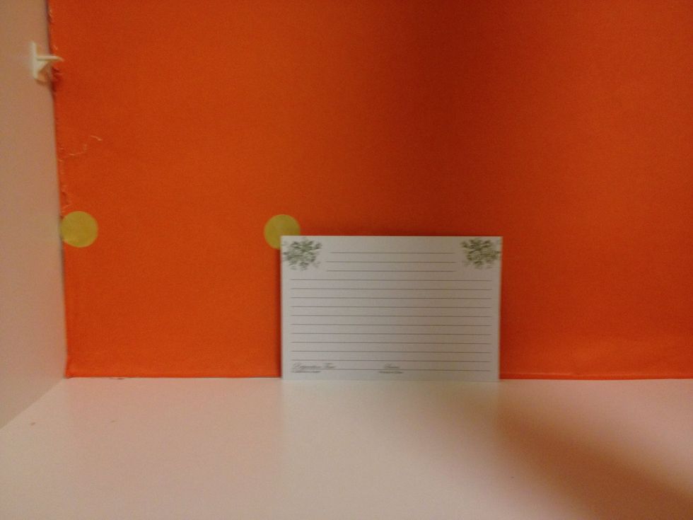 Peel the now gold sticker and place on the back of your cabinet. I used an index card to help space the stickers evenly to create the polka dot pattern.