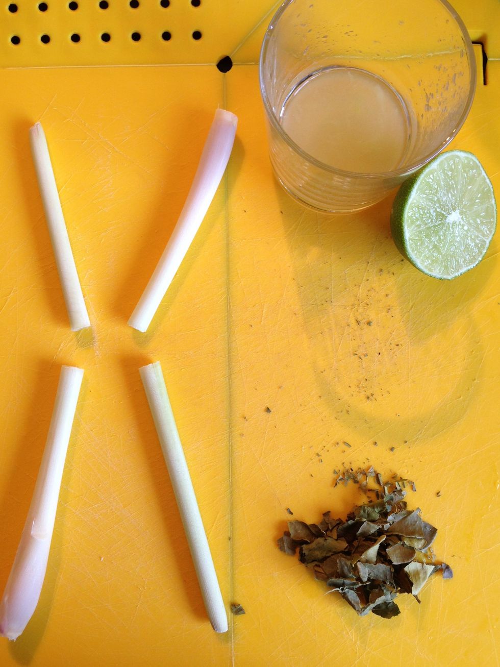 Peel the outer skin from lemon grass sticks and chop it in halves. Chop the Kaffir leaves finely and squeeze half of your lime juice into a cup.
