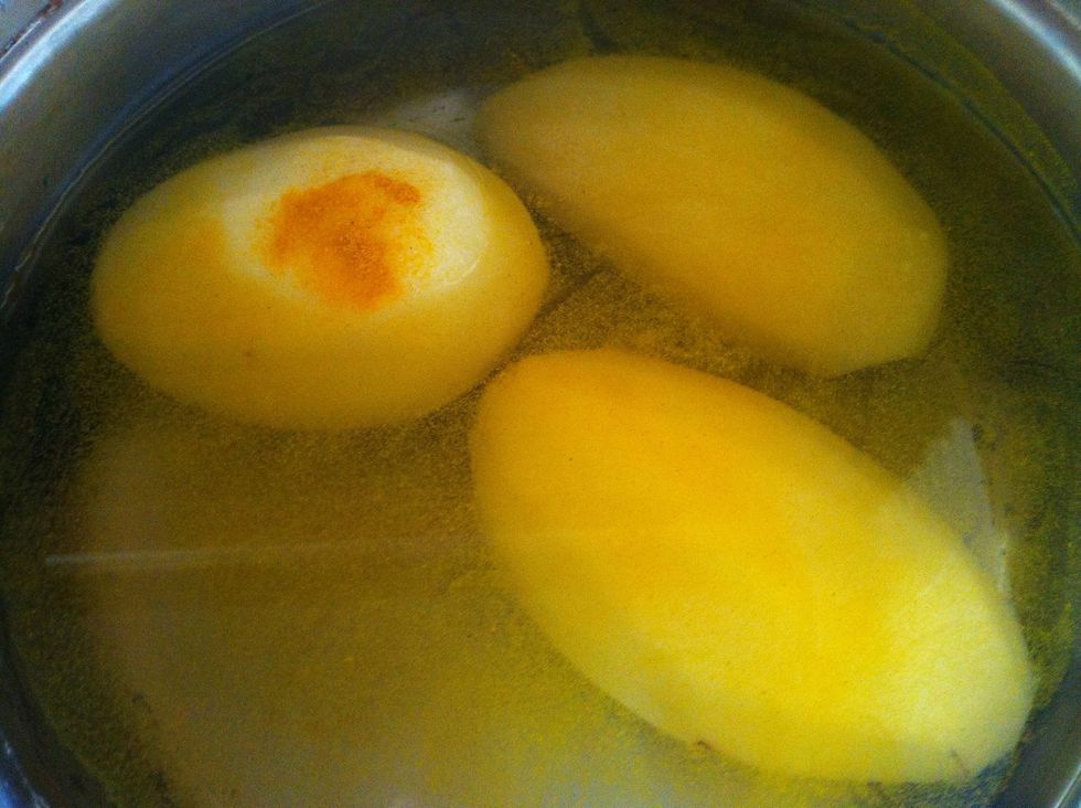 Peel them. Wash them. Place them in a pot with a pinch of salt and a pinch of turmeric. Ensure the potatoes are submerged.Boil for 10 mins on medium heat. It's essential the potatoes are kept whole.