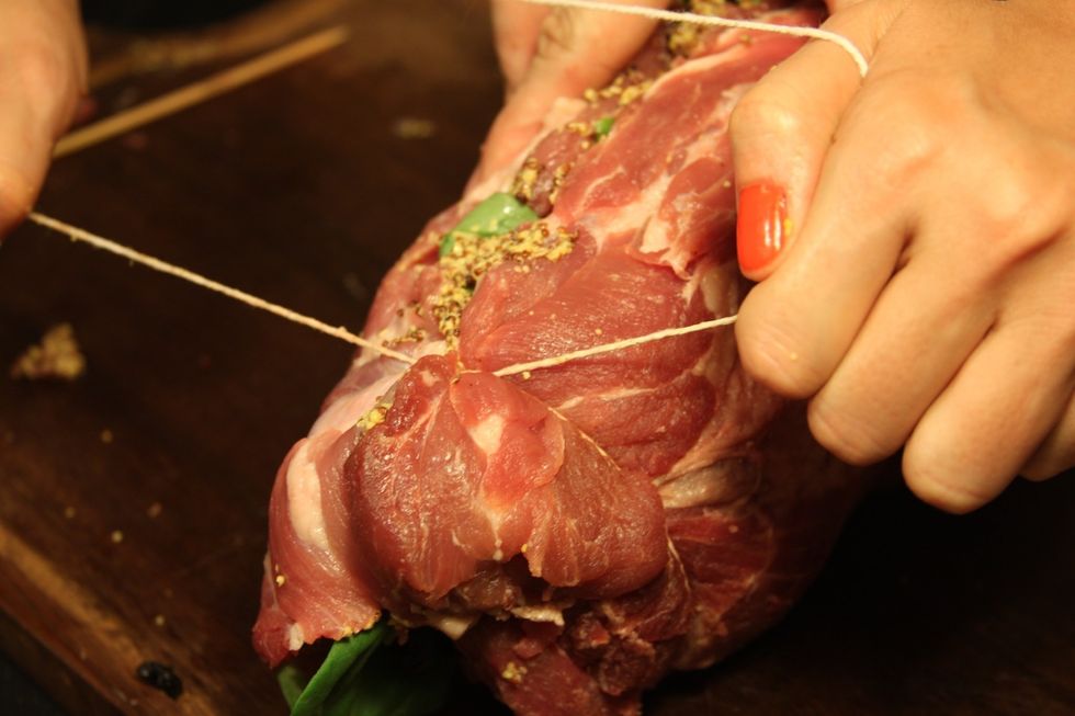Pegue o barbante e segure uma das pontas da carne. Pase o barbante em volta e segure com un n\u00f3.