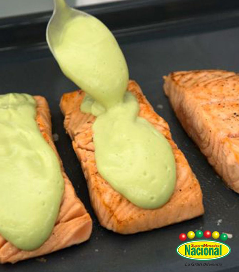 Pela y troc\u00e9a el aguacate y ponlo en la batidora. Sazona, agrega zumo de lim\u00f3n, leche y 2 cucharadas de aceite, haz un pur\u00e9. Pon el pescado en el horno, c\u00fabrelo con el mojo y grat\u00ednalo por 10 minutos.
