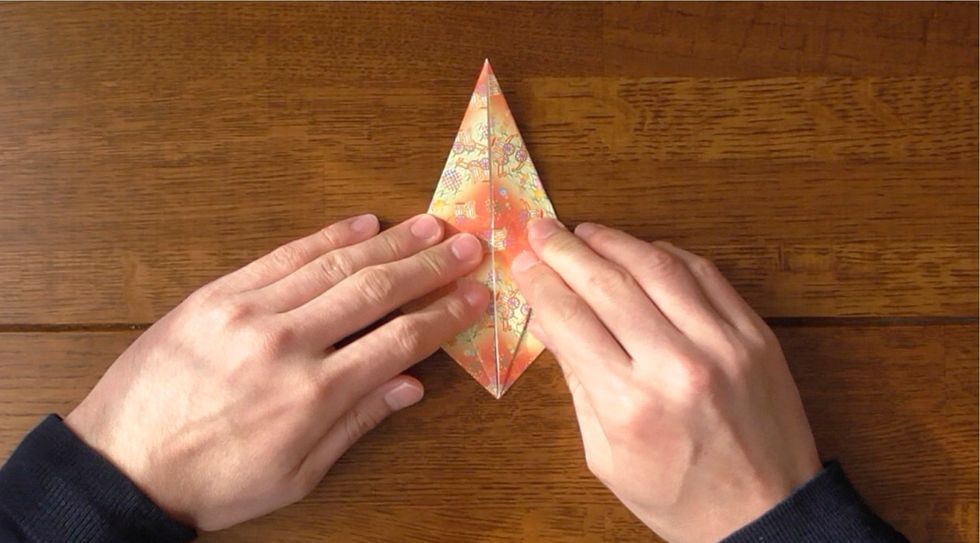 Petal fold bottom corner to the top using existing creases.  Fold raw edges to the center and unfold.  Petal fold bottom corner to the top using existing creases.