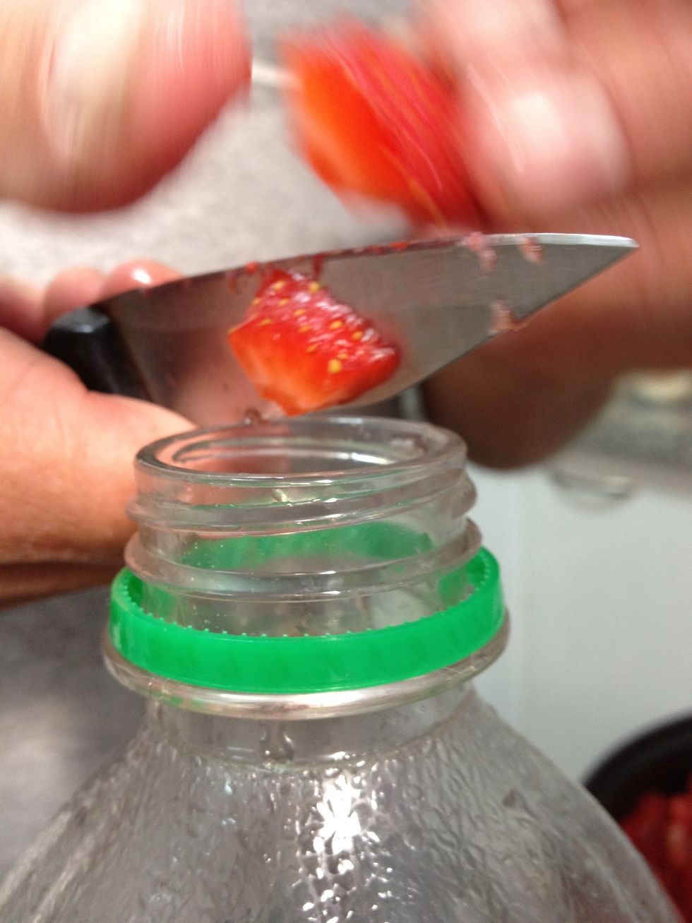 Picar la frutilla y meterla dentro de la botella