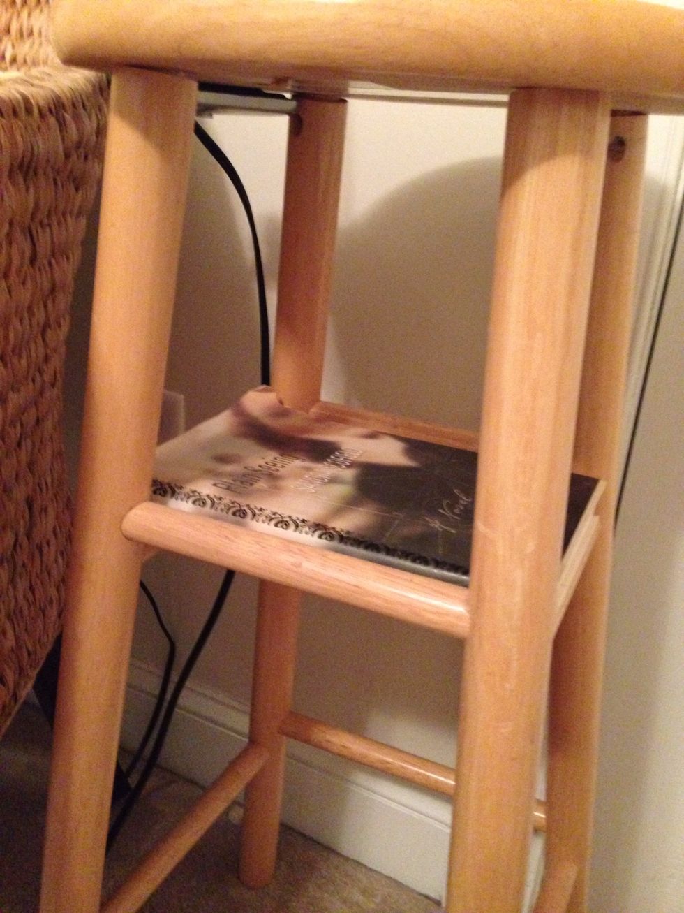 Pick a book that is the right size to be the shelf. It needs to be long enough to span two chair rungs.