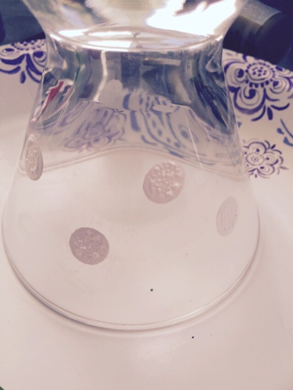 Pick a couple of colors that are near each other on the rainbow and white. Start painting white dots near the top of the glass.