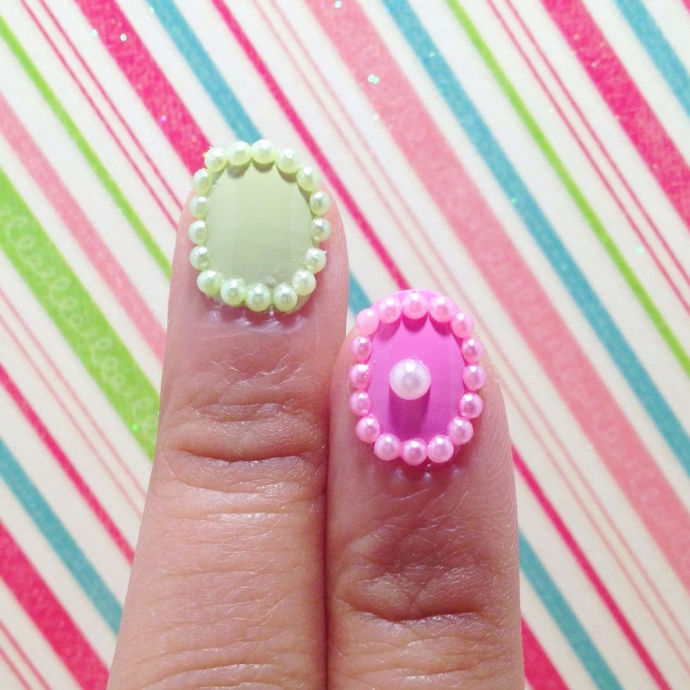 Pick pearls of the same color. Use a dotter, dab a dot of clear coat on the border of your nail. Use the dotter to pick up a pearl and place it where you placed the clear coat dot.