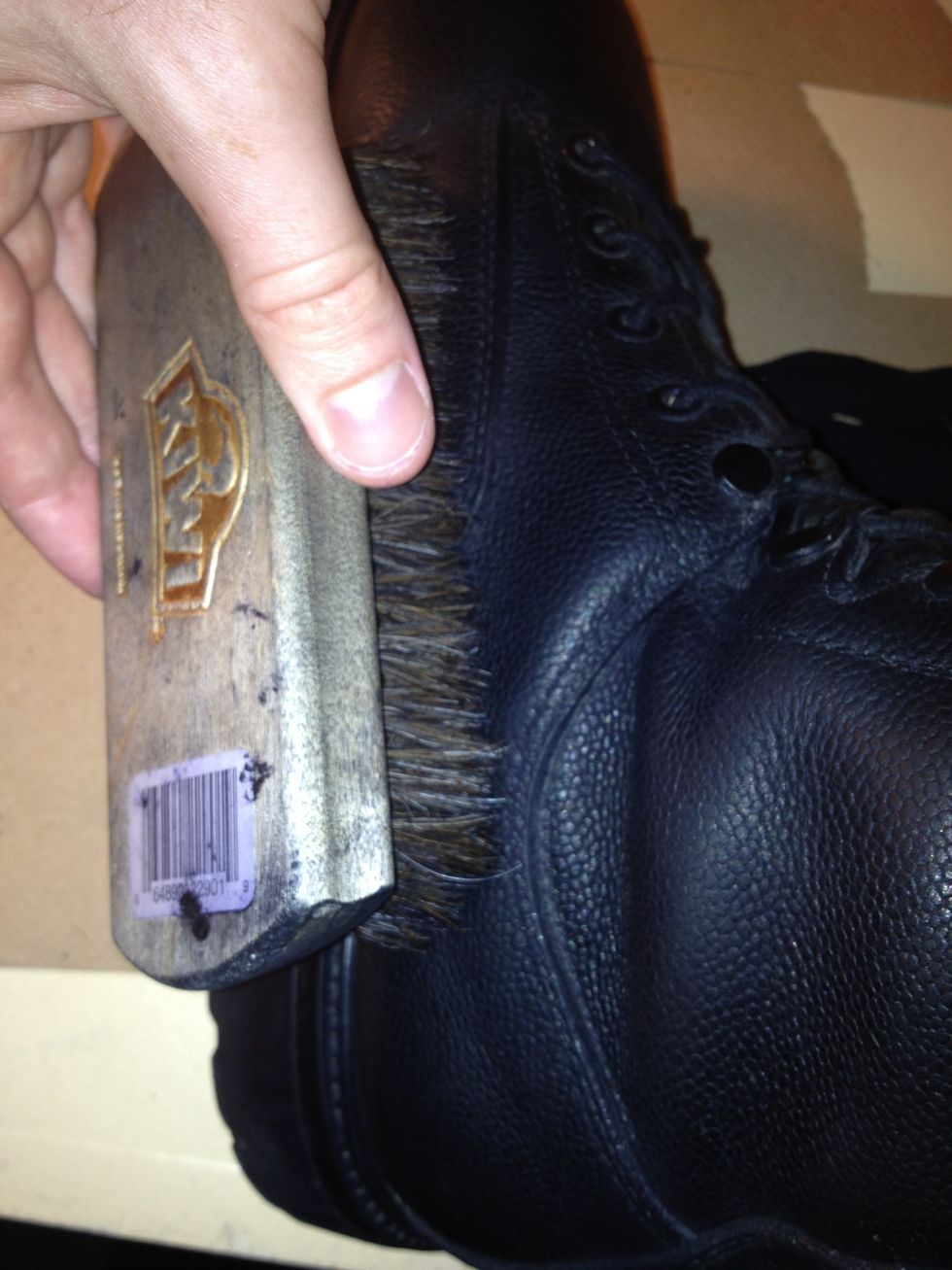 Pick the first boot back up and use the large brush to brush off the polish that's been seeping into the pores of the leather.