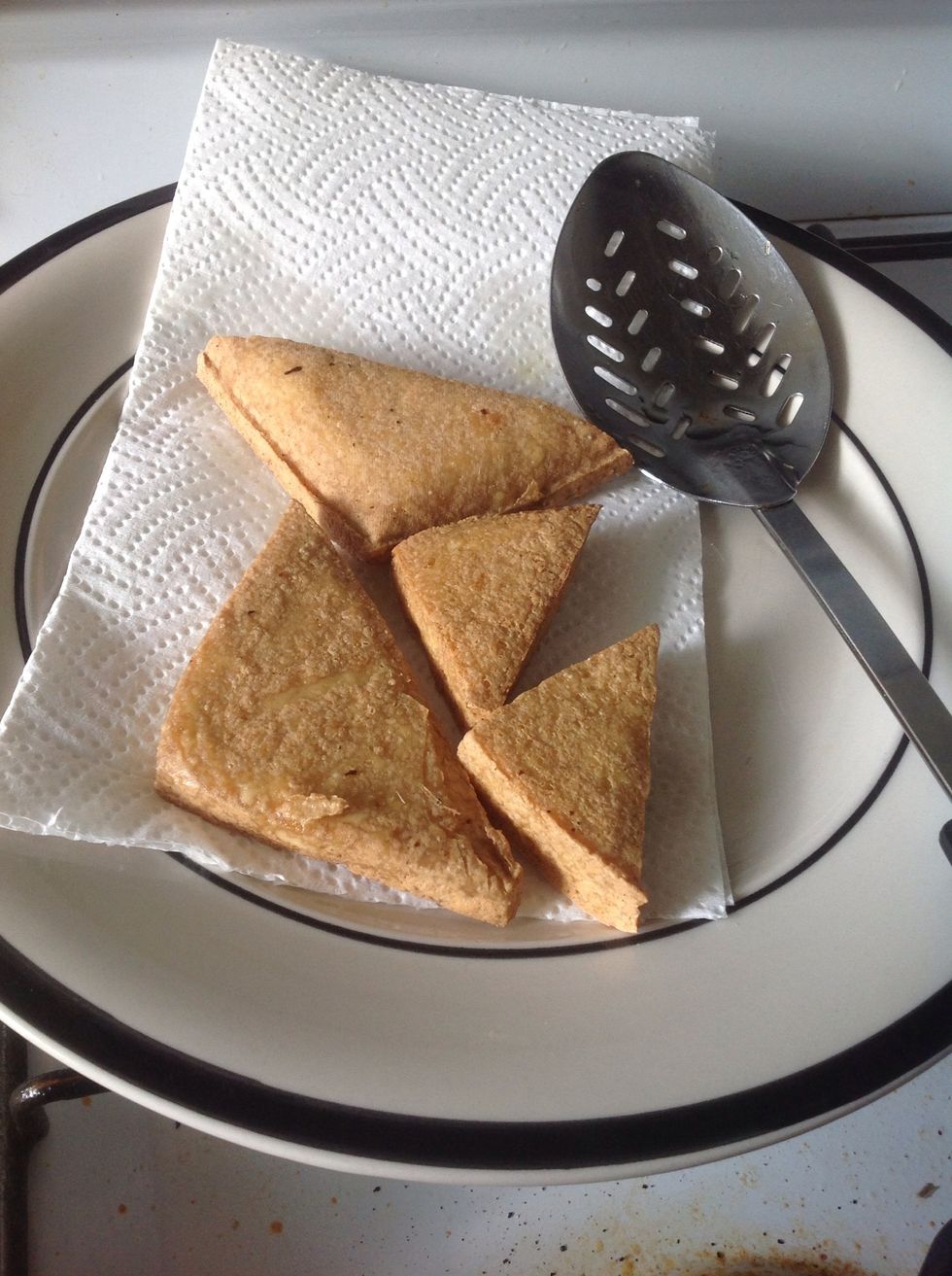 Pick them out and lay on an oil removing paper. If you can buy fried tofu, just quick fry them