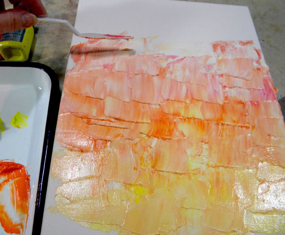 Pick up a generous amount of Lemon Tart and super heavy gesso on a palette knife and spread on the canvas in short strokes. Alternate applying Tango, Persimmon, and Fiesta Velvets with the gesso.