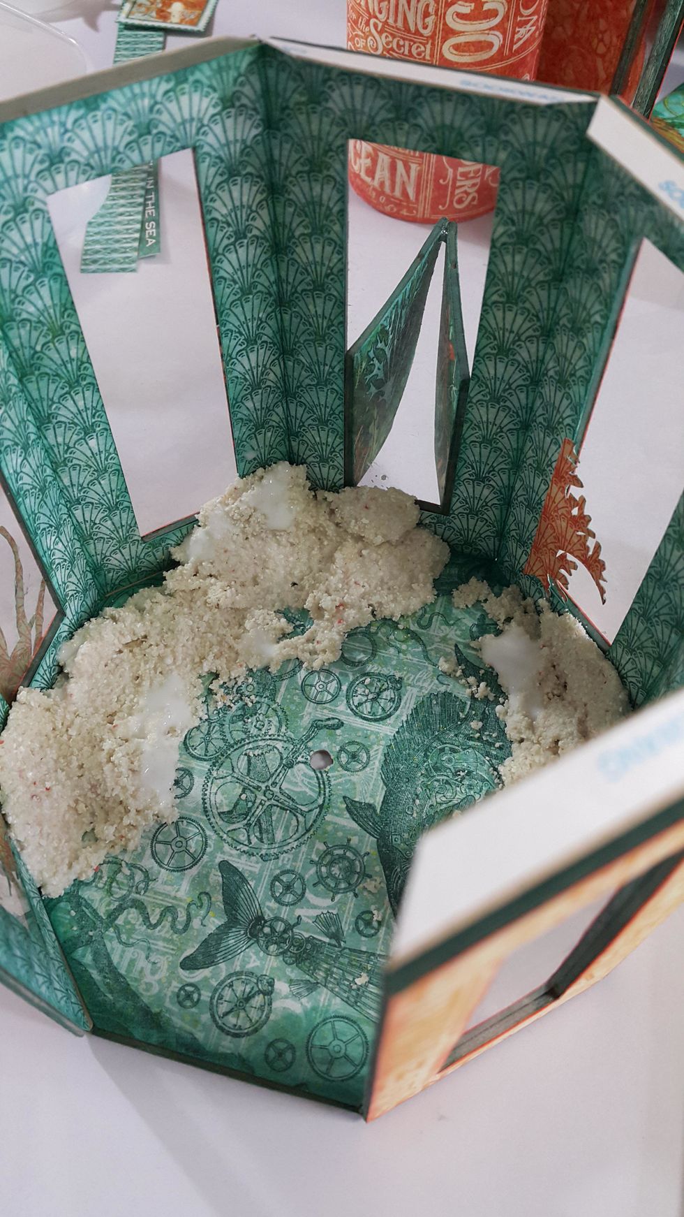 Pick up the panels and the plain octagon from steps 3 and 4. Adhere the panels on the octagon, cover the base with paper, then punch a hole in the middle.